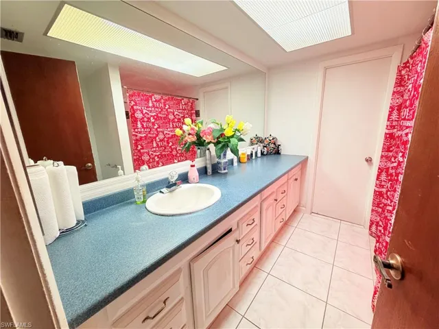 Bathroom with vanity, curtained shower, and light tile patterned floors