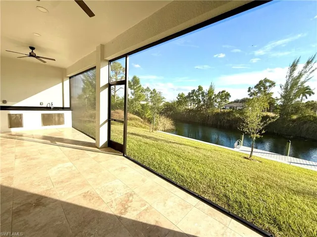 Sunroom featuring a water view and tile patterned flooring and summer kitchen.