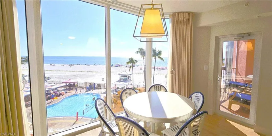 Dining area featuring view of water and beach and wood finished floors