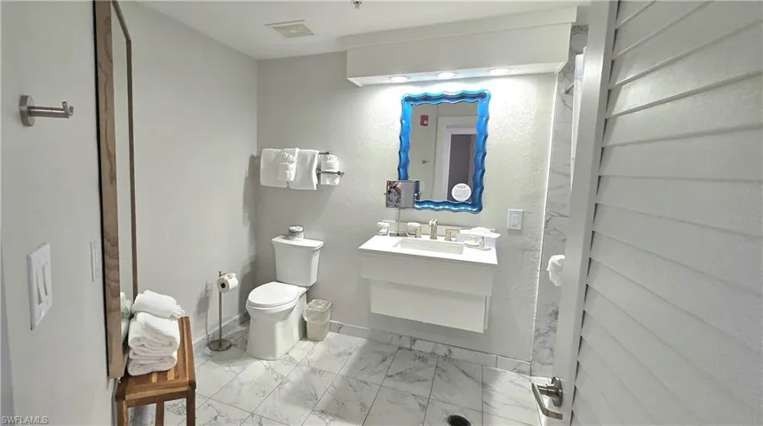 Bathroom with vanity and light marble finish floors