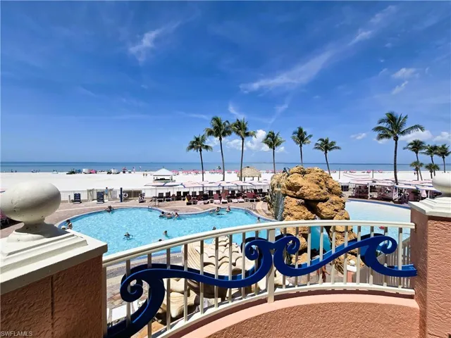 Balcony featuring a beach view and view of pool area