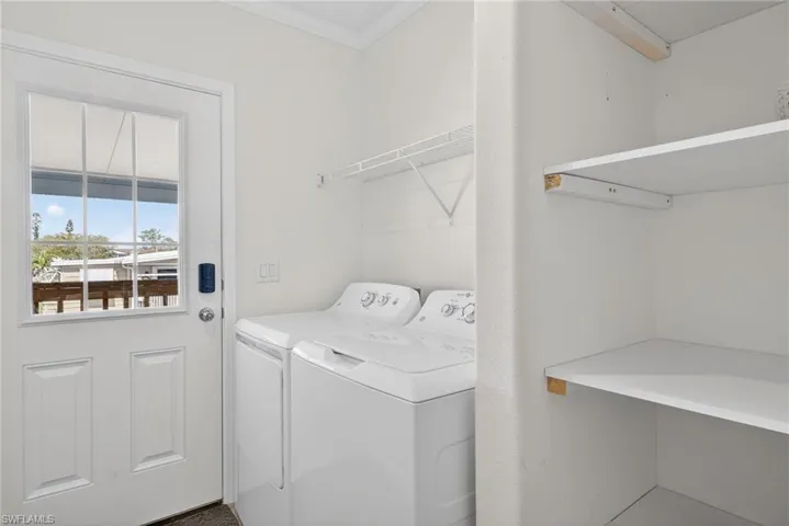Laundry area featuring washer and clothes dryer and shelving