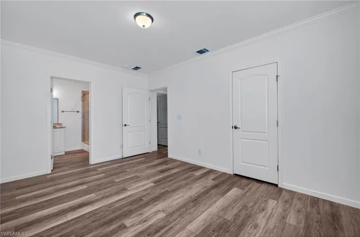 Primary Bedroom with view into Primary Bath and Closet