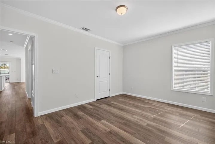 Primary Bedroom with view of Closet Door and Hallway to Living/Kitchen