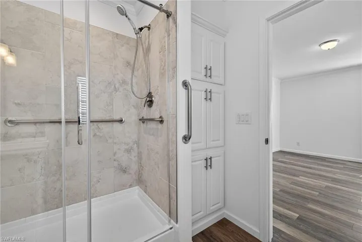 Full bathroom with a shower stall and storage cabinets
