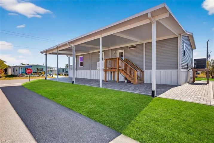 Manufactured home featuring elevated home, driveway and elevated HVAC
