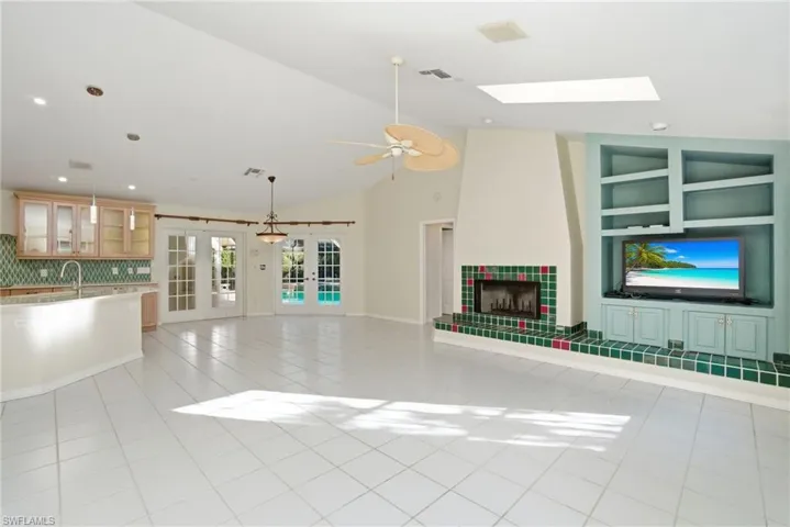 Family Room with Vaulted Ceilings + Fireplace - Out to Pool