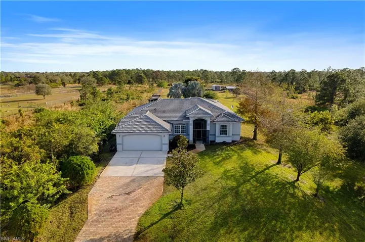 View of front of property featuring a garage and a front lawn