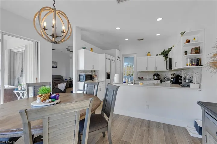 Dining area featuring sink, light hardwood / wood-style flooring, and an inviting chandelier