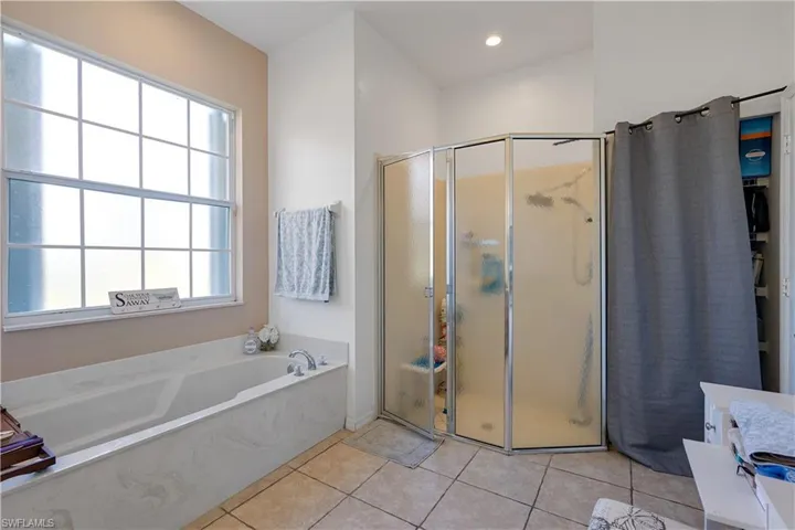 Bathroom with tile patterned floors, plenty of natural light, and plus walk in shower