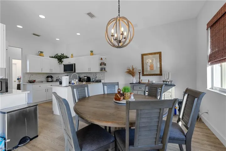 Dining room featuring light wood-type flooring and an inviting chandelier