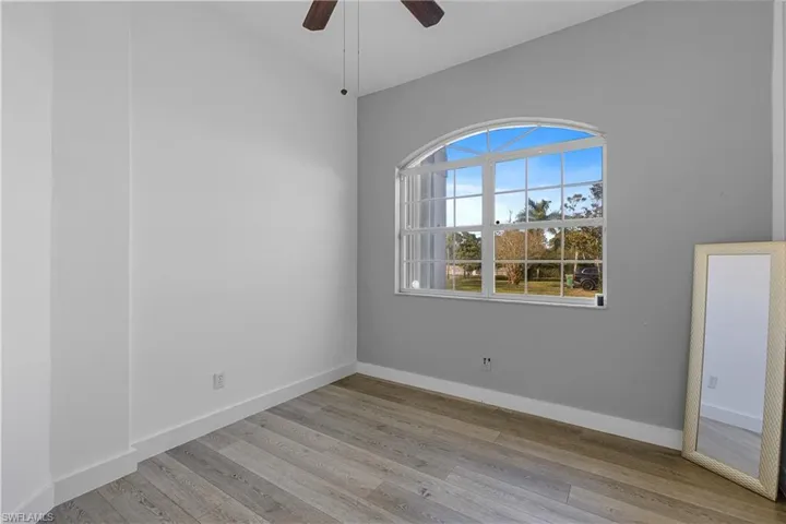 Empty room with ceiling fan and light hardwood / wood-style floors
