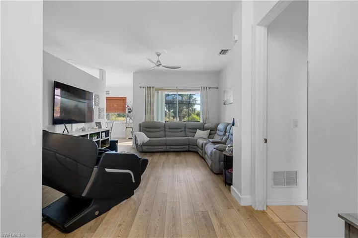 Living room with light wood-type flooring and ceiling fan