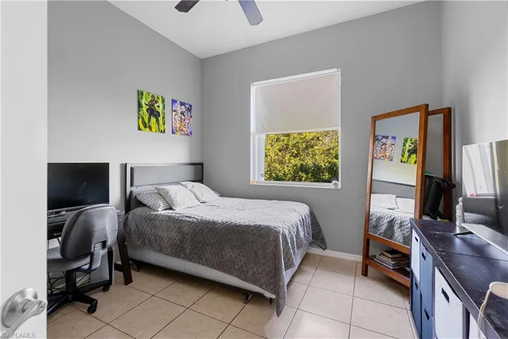 Bedroom with ceiling fan and light tile patterned flooring