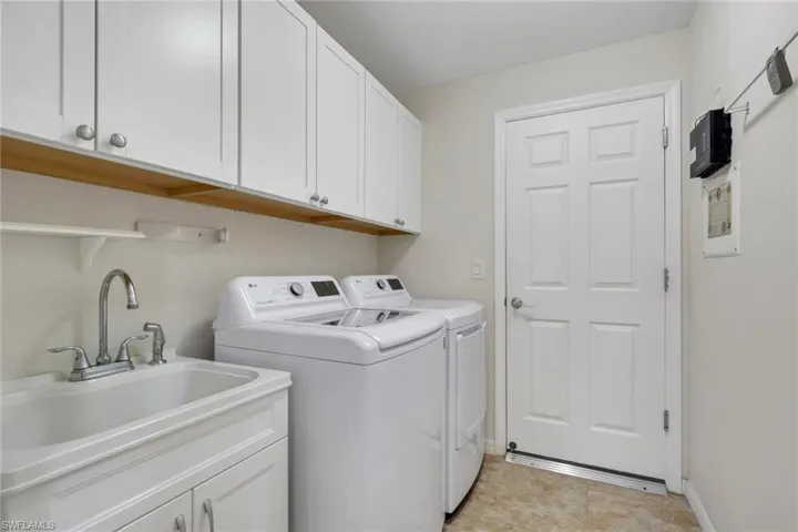 Laundry area with cabinet space and washing machine and clothes dryer