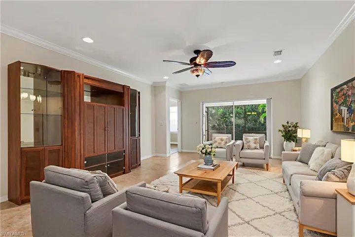 Living area with ornamental molding, ceiling fan, and recessed lighting