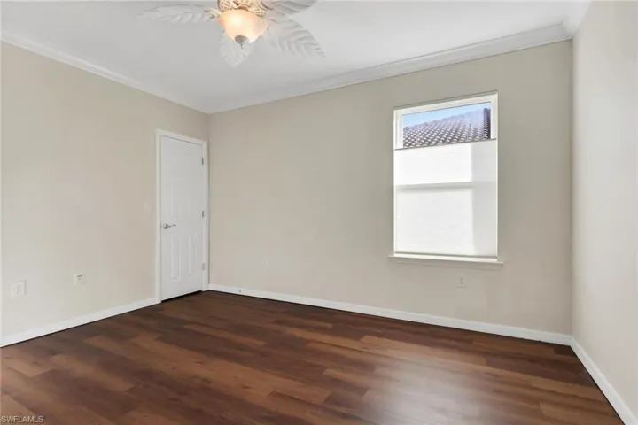 Unfurnished room featuring ornamental molding and dark wood-style flooring