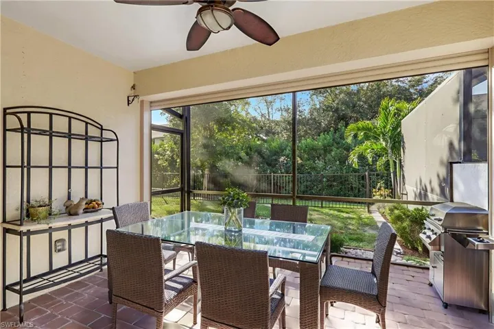 Sunroom featuring outdoor dining area, a ceiling fan, and a patio area