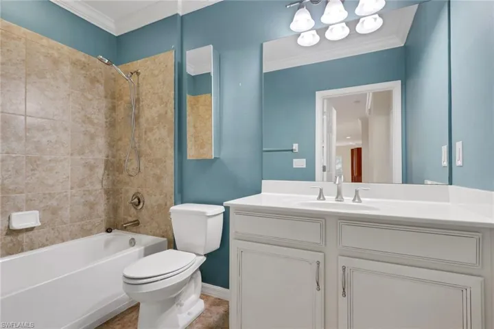 Full bathroom with tub / shower combination, crown molding, vanity, and a chandelier