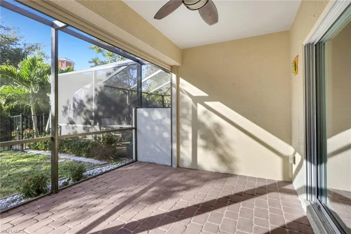 Unfurnished sunroom with ceiling fan and a patio area
