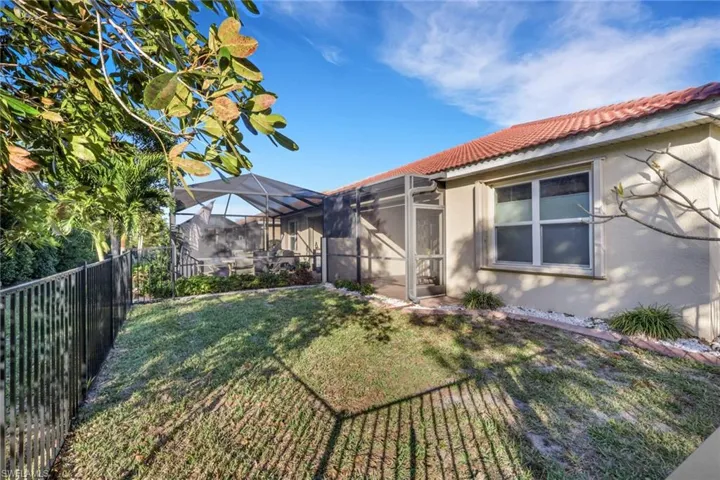 Fenced backyard with a sunroom and a lanai