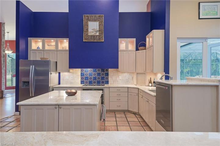 Kitchen island and bar with newer counters and backsplash