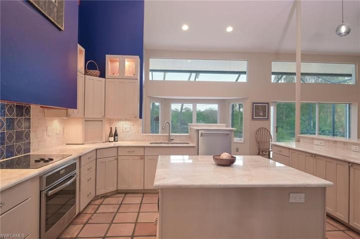 So much natural light in the home - the many windows, pocket sliders, & French doors add to the warmth. Newer quartzite counters and travertine backsplash, cabinet lighting, new dishwasher