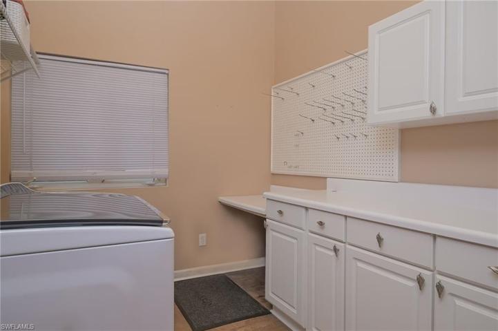 large laundry area with storage near primary bedroom