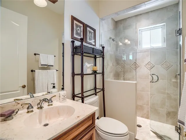 2nd floor guest bathroom featuring tiled shower, vanity, and toilet