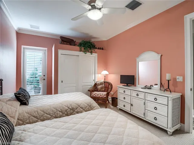 Bedroom with light carpet, closet, ceiling fan, exiting to private courtyard