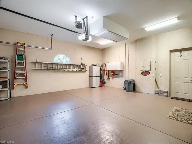 Home has 3 car garages split 2/1. Pictured oversized 2 car with epoxy coated flooring sink and storage cabinets.