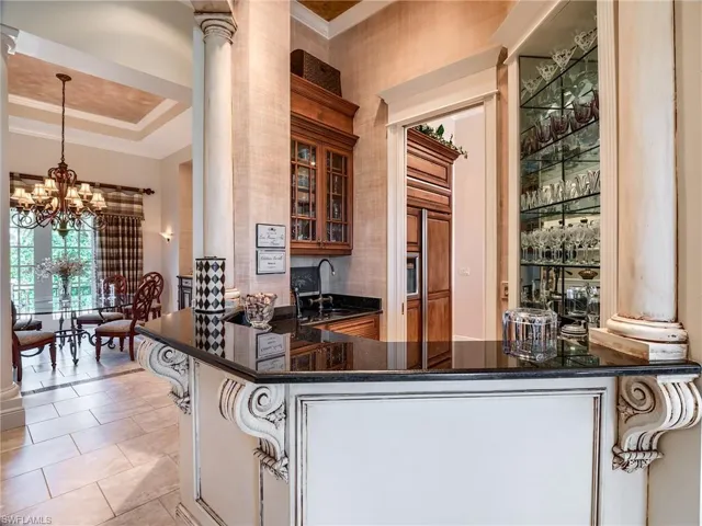 Wet bar off Kitchen with wine coolerWet bar with wine cooler and custom cabinetry centrally located between living, dining, kitchen and family rooms