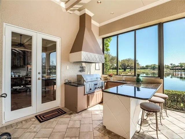 Outdoor kitchen with infra-red gas grill, sink, exhaust fan, and counter height seating