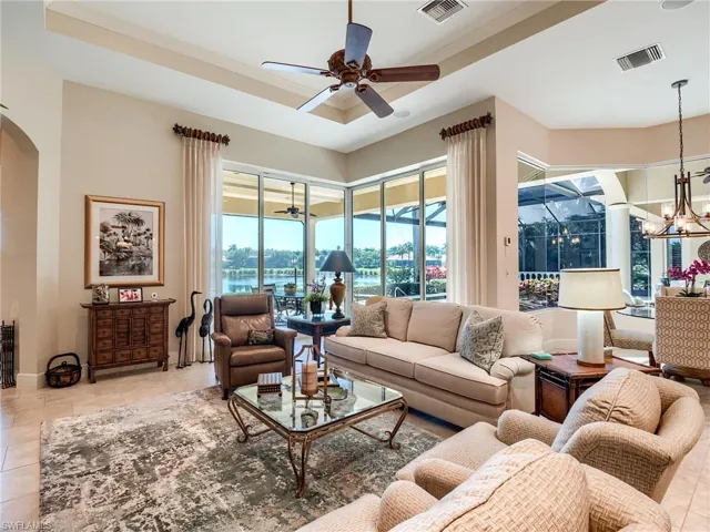 Family room with tray ceiling, ceiling fan and impact glass sliders opening to the lanai
