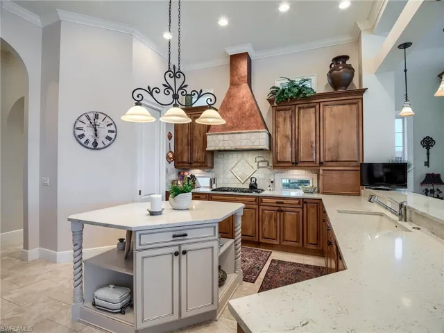 Kitchen featuring hanging light fixtures, a center island, tasteful backsplash, and custom exhaust hood