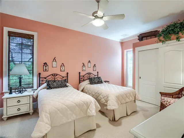 Carpeted bedroom featuring a closet, ceiling fan, private exit to courtyard and ensuite bathroom