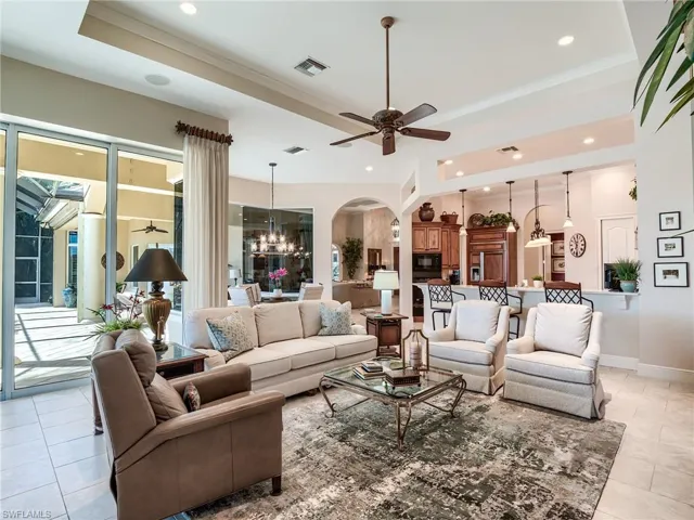 Family room with tray ceiling, ceiling fan and light tile floors