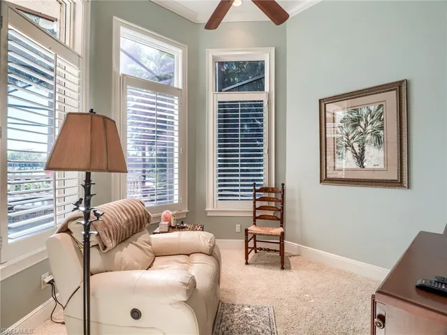 Sitting room featuring plenty of natural light, ceiling fan, neutral carpet floors, and crown molding