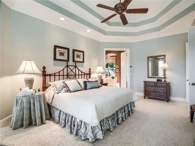 Bedroom featuring double tray ceiling fan with crown molding, ceiling fan, and neutral colored carpet