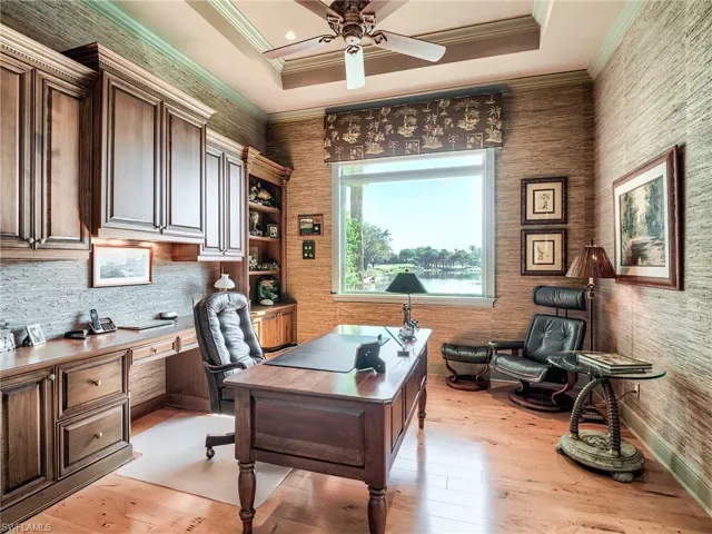 Office area featuring tray ceiling, light hardwood floors, custom built-ins and great views