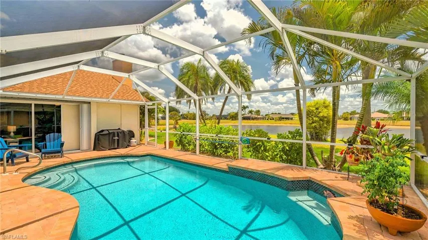 Swimming pool featuring a water view, glass enclosure, and a patio