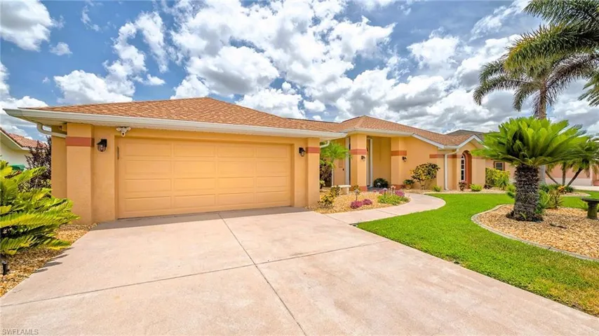 View of front of property featuring stucco siding, driveway, an attached garage, and a front yard