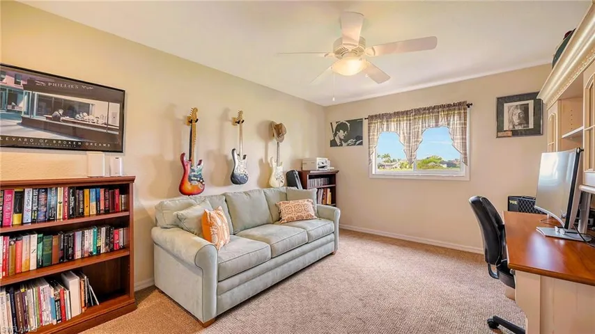 Office space with a ceiling fan, carpet, and baseboards
