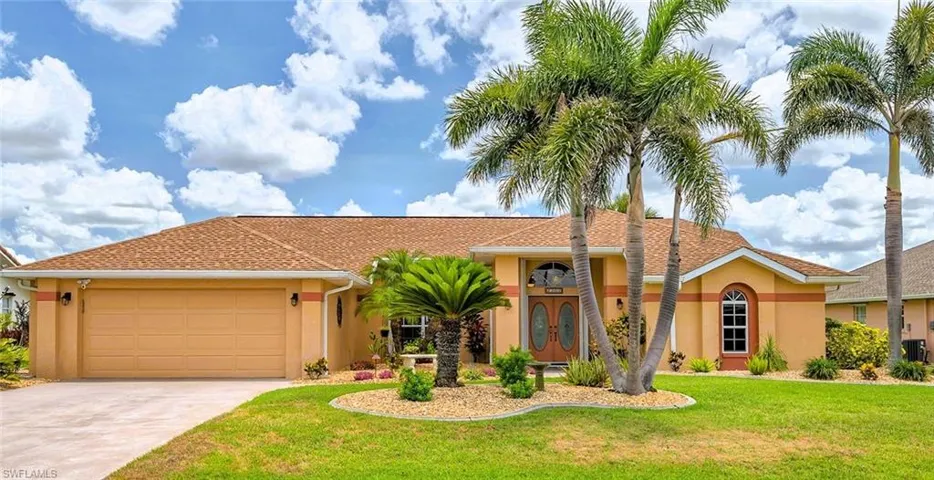 Mediterranean / spanish home with stucco siding, an attached garage, a front yard, and driveway
