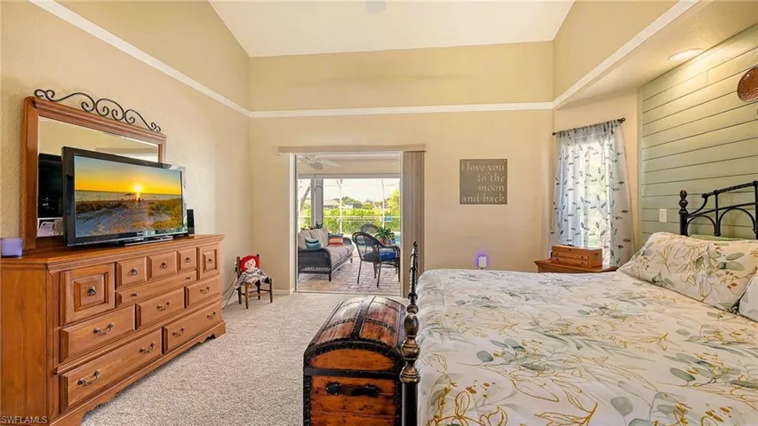Bedroom featuring access to exterior, light colored carpet, and high vaulted ceiling