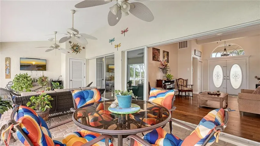 Dining space with ceiling fan, high vaulted ceiling, plenty of natural light, and wood finished floors