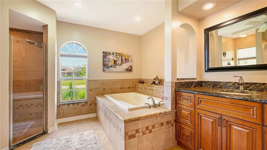 Bathroom featuring vanity, a bath, a shower stall, recessed lighting, and tile patterned flooring