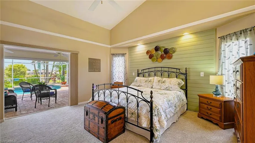 Bedroom with access to exterior, light carpet, high vaulted ceiling, and a ceiling fan