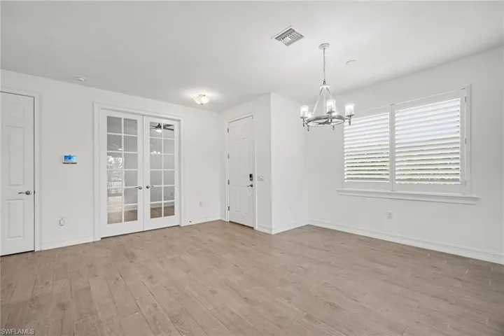 Spacious interior featuring wood-finish flooring, white walls, and French doors with glass panes