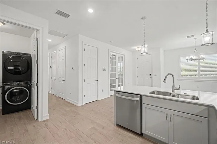 Modern kitchen island featuring a double-basin stainless steel sink, gooseneck faucet, and integrated dishwasher